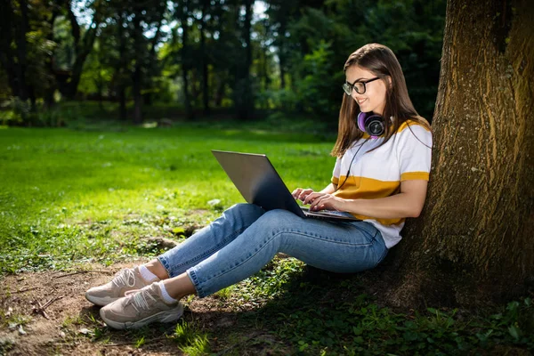 可爱的女孩使用笔记本电脑在公园 — 图库照片