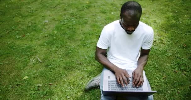 Estudiante afroamericano escribiendo en la vista superior del ordenador portátil — Vídeos de Stock
