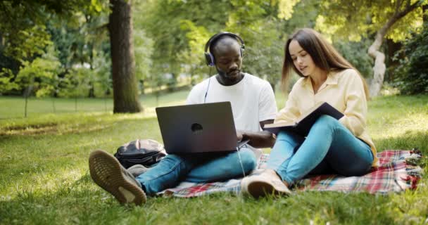 Multirassische Freunde lernen im Park — Stockvideo