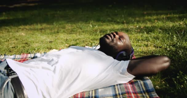 Афро-американський людина, насолоджуючись музикою в парку — стокове відео