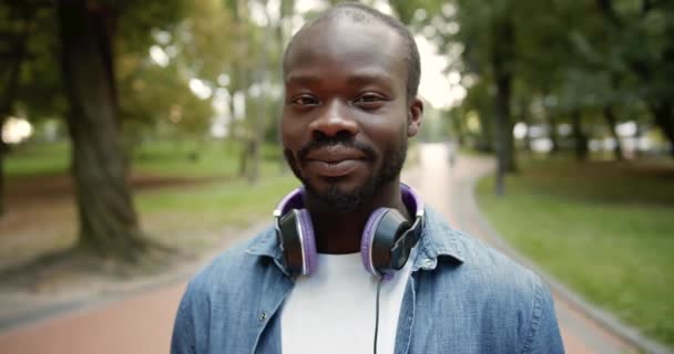 Porträtt av Afro-American i hörlurar utomhus — Stockvideo