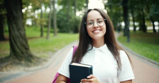 Portret studentki z książką w parku — Wideo stockowe