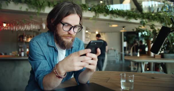 Manlig surfar smartphone i Cafe — Stockvideo