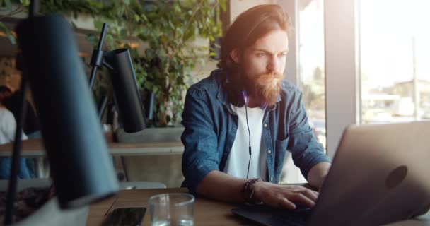 Man arbetar på laptop nära fönster — Stockvideo