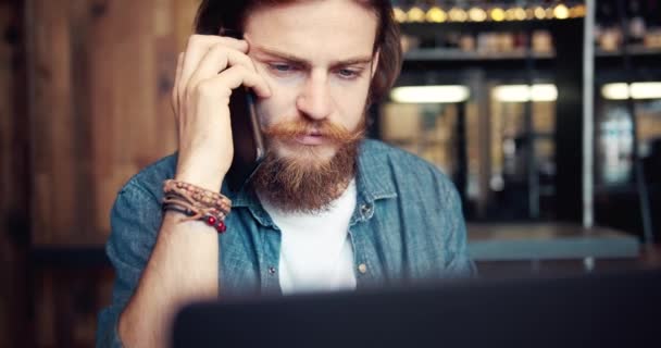 Upptagen man med smartphone och laptop i Cafe — Stockvideo