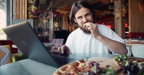 Fókuszált hím-val laptop étkezési pizza — Stock videók