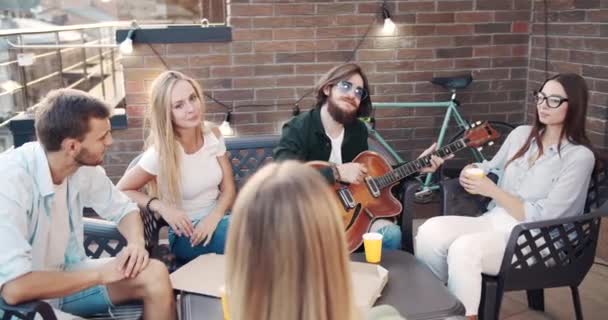 Amigos Relajarse y tocar la guitarra en la terraza — Vídeos de Stock