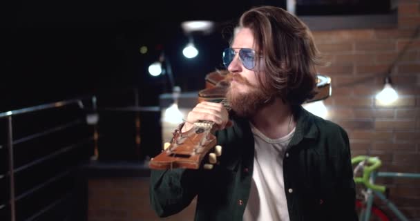 Hombre sosteniendo la guitarra en el retrato de hombro — Vídeo de stock