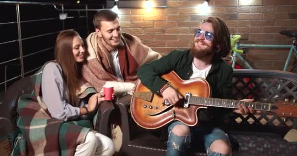 Amigos tocando guitarra e relaxando à noite — Vídeo de Stock