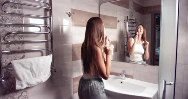 Mulher limpeza de dentes no banheiro — Vídeo de Stock
