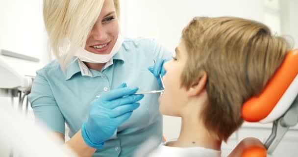 Amistoso dentista examinando chico — Vídeo de stock