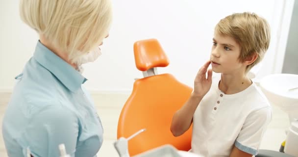 Dentista amigável conversando com o menino — Vídeo de Stock