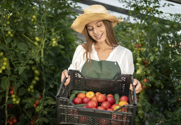 Jolie paysanne montrant une caisse de tomates — Photo
