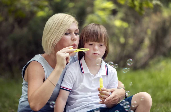 Loving Mother and Special Boy Playing Soap Bubbles