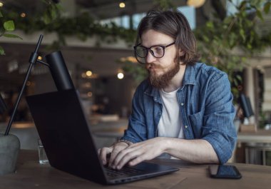 Laptop kullanan Düşünceli Sakallı Genç