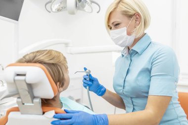 Gülümseyen Gözlü Pediyatrik Diş Doktoru Su püskürtme şırıngası kullanıyor