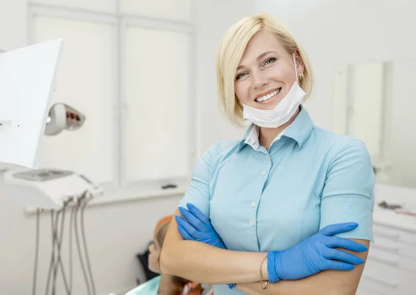 Dentista loira bonito em esfoliação azul e luvas posando — Fotografia de Stock