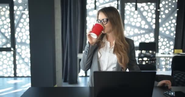 Geschäftsfrau verkostet Kaffee im Büro — Stockvideo