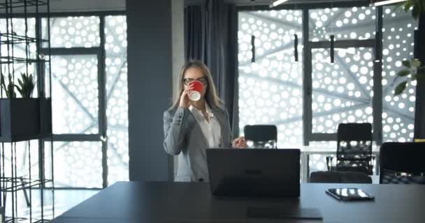 Geschäftsfrau verkostet Kaffee im Büro — Stockvideo