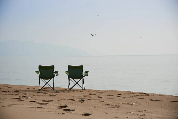 fishing chairs on the sandy beach