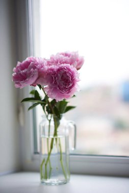 Vazodaki güzel şakayıklar masada.