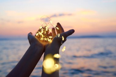 Noel ışıklarını tutan eller 