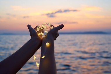 Noel ışıklarını tutan eller 