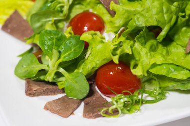 Lezzetli yemekler tabağa yakın görünüyor.