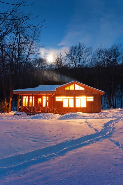 雪に覆われた森の中の小さな木造の家 — ストック写真