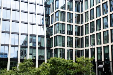 bahçede yeşil ağaçlar ile mimari ofis camlar