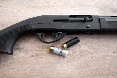 semi-automatic black hunting shotgun and cartridges 12 gauge, close-up view clipart