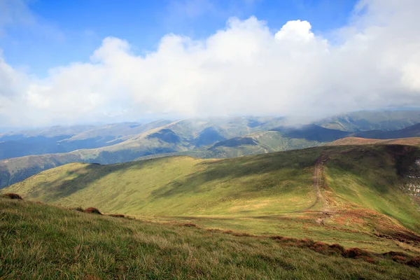 緑山の尾根 灰色の雲の青い背景の丘 — ストック写真