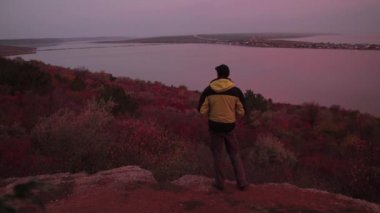 Uzun yürüyüşe çıkan kimse kenarında duran adam ve vanilya gündoğumu gölde yol ışıkları hayranım