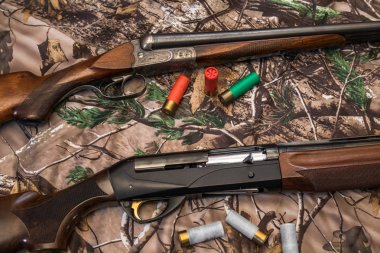 16 ve 12 ölçer ve kartuşları kamuflaj arka plan üzerinde iki av tüfeği