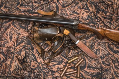 kamuflaj arka plan üzerinde double-barreled antika tüfek, bıçak ve mühimmat kemer