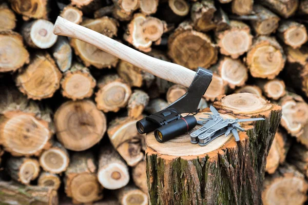 Axt Fernglas Und Multifunktionsmesseretui Auf Dem Baumstumpf Feuerholz Hintergrund — Stockfoto