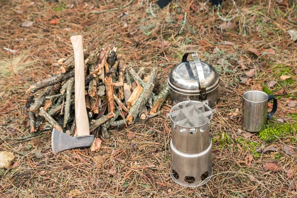 斧头附近的火林 野营木炉 野营用具和背包的背景 — 图库照片