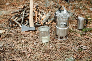 yakınındaki bir çeşidinde, mutfak eşyaları ve sırt çantası ve arka plan üzerinde kamp kamp woodstove axe