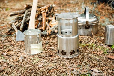 yakınındaki bir çeşidinde, mutfak eşyaları ve sırt çantası ve arka plan üzerinde kamp kamp woodstove axe
