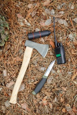 Balta, tek gözlük, turist bıçak ve radyo çam iğneleri ile kaplı zeminde ayarla