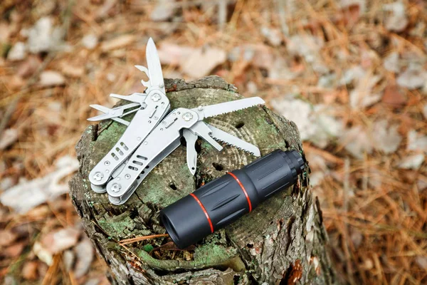 multitool bıçak ve sonbahar ormandaki güdük üzerinde tek gözlük
