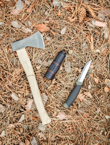 Ascia, monocolo e coltello turistico a terra ricoperto di aghi di pino — Foto Stock