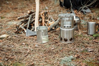 yakınındaki bir çeşidinde, mutfak eşyaları ve sırt çantası ve arka plan üzerinde kamp kamp woodstove axe