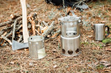 yakınındaki bir çeşidinde, mutfak eşyaları ve sırt çantası ve arka plan üzerinde kamp kamp woodstove axe