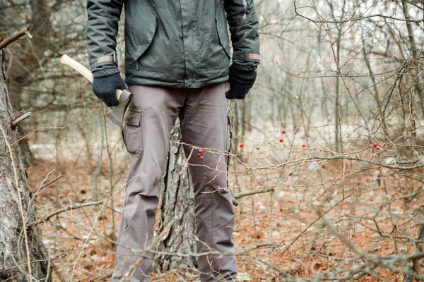 Mężczyzna szuka firewoods w lesie jesienią z siekierą — Zdjęcie stockowe