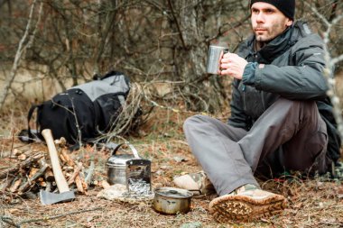 adam rahatlatıcı orman kamp, odun sobası, mutfak eşyaları ve çeşidinde baltayla yakın