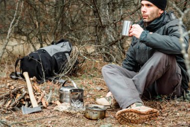 adam rahatlatıcı orman kamp, odun sobası, mutfak eşyaları ve çeşidinde baltayla yakın