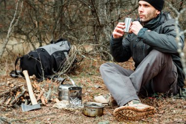 adam rahatlatıcı orman kamp, odun sobası, mutfak eşyaları ve çeşidinde baltayla yakın