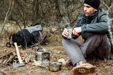adam rahatlatıcı orman kamp, odun sobası, mutfak eşyaları ve çeşidinde baltayla yakın