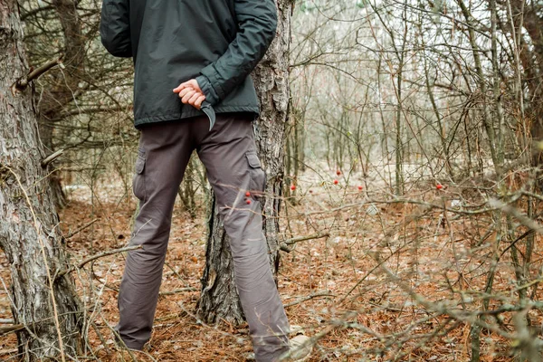 Mężczyzna z nożem, ukrywając się w lesie jesienią i będzie zrobić karnego — Zdjęcie stockowe
